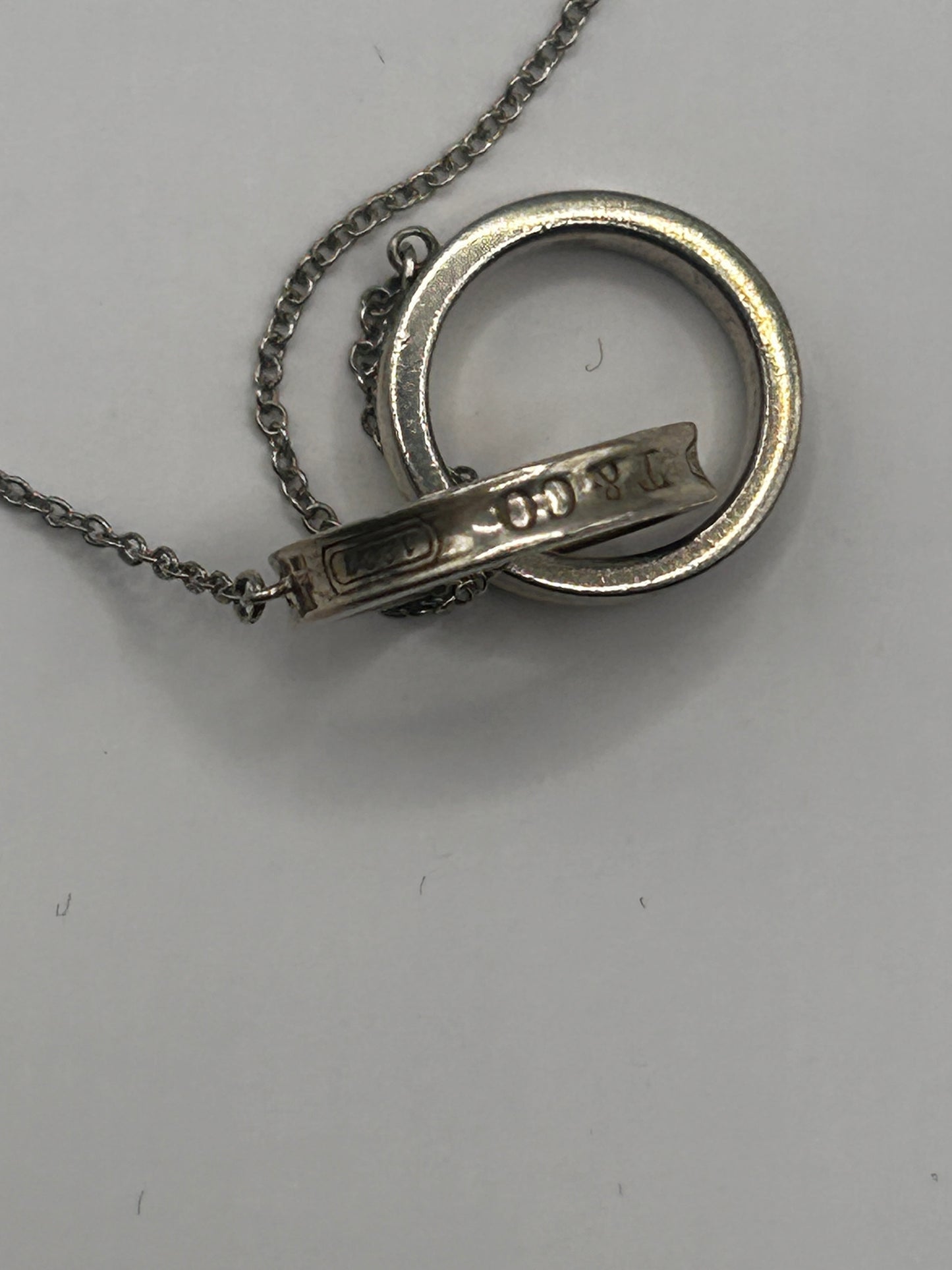 Tiffany & Co. 1837
Interlocking Circles Pendant in sterling silver, highlighted by its signature engraved hallmark and interlocking ring design.